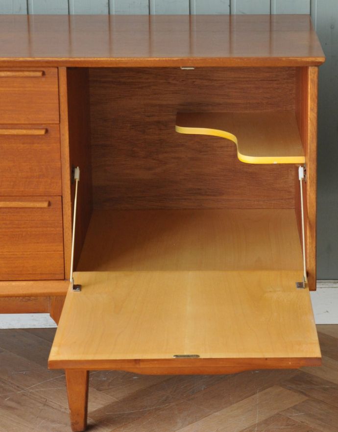 アンティークのキャビネット　アンティーク家具　チーク材のゆったりサイズなビンテージ家具、シンプルなサイドボード。棚板の形が工夫されているので、ボトルや花器など高さのある物の収納も可能です。(x-804-f)