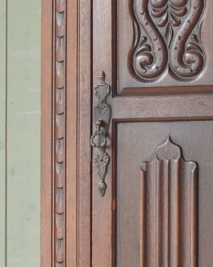 ワードローブ　アンティーク家具　英国輸入のアンティーク家具、立体的な彫がキレイな扉のワードローブ。アンティークの風合いたっぷりの取っ手もアクセントになっています。(j-1922-f)
