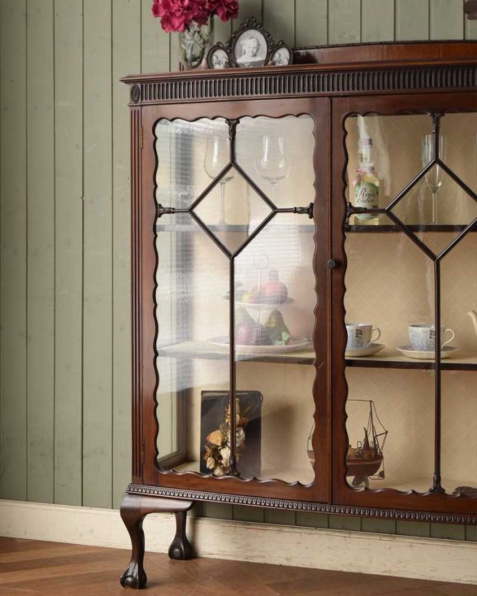 アンティークのキャビネット　アンティーク家具　マホガニー材のアンティーク英国家具、装飾が美しいガラスキャビネット。木で描かれたガラス扉の模様の美しさにうっとり･･･まだ機械のない時代に、どうやって作られたんだろう…と不思議になるくらい美しいガラス面に描かれた美しい木の模様が特長。(j-2190-f)
