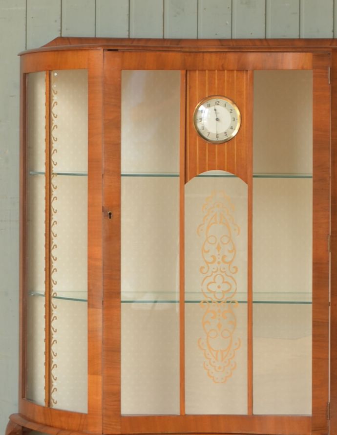 アンティークのキャビネット　アンティーク家具　ゴールドの装飾×時計が付いた英国アンティークのガラスキャビネット（飾り棚）。アンティークのガラスがキレイにはめ込んであります。(k-1299-f)