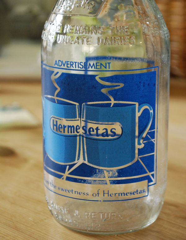 ナチュラルカントリースタイル　アンティーク雑貨　イラスト入りで可愛いイギリスの牛乳ビン、アンティークガラスボトル（Hermesetas）。鮮やかなブルーのマグが可愛い！配色もカラフルで、見ているだけで楽しいデザインです。(k-1357-z)