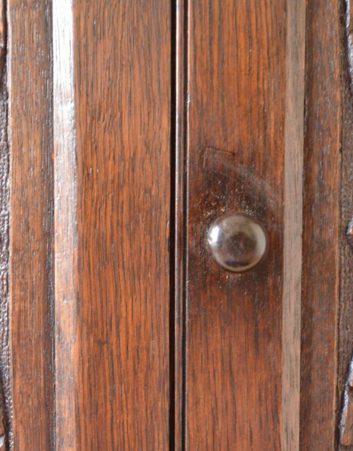 アンティークのキャビネット　アンティーク家具　英国スタイルのアンティーク家具、扉の彫りが美しい小さなカップボード（食器棚） 。アンティークの風合いがある木製の取っ手がちょこんと付いています。(k-1438-f)