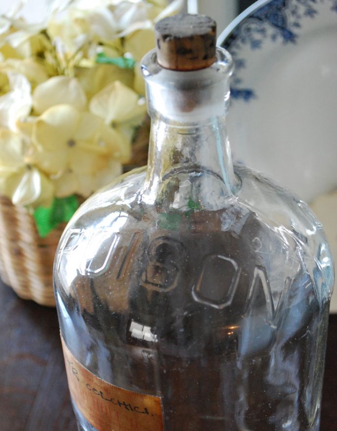ナチュラルカントリースタイル　アンティーク雑貨　コルク付きの大きなアンティークガラスボトル （ラベル付き）。長年使われてきたボトルはとっても味わい深い一品です。(k-1638-z)