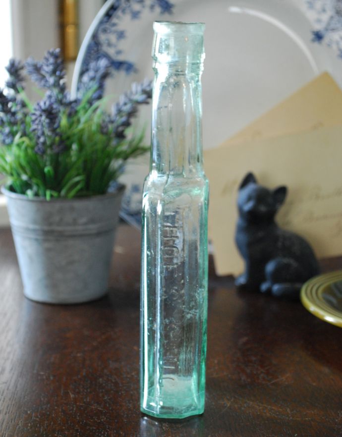 ナチュラルカントリースタイル　アンティーク雑貨　背の高いガラスボトル、淡いグリーンのエンボス入りボトル。長年使われてきたボトルはとっても味わい深い一品です。(k-1643-z)