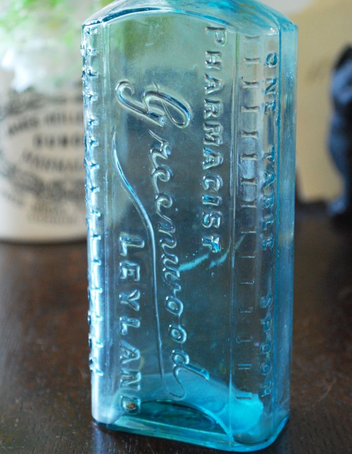 ナチュラルカントリースタイル　アンティーク雑貨　アンティークの目盛りつきガラスボトル、お洒落なエンボス入り。ミルクや薬品、調味料など様々な用途で使われてきたアンティークボトルたちです。(k-1644-z)