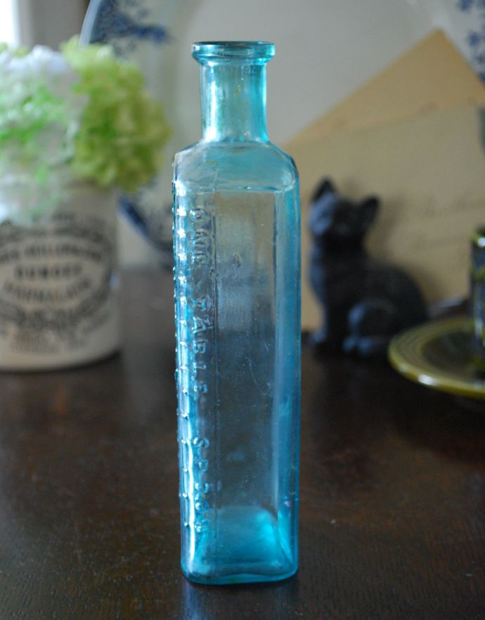 ナチュラルカントリースタイル　アンティーク雑貨　アンティークの目盛りつきガラスボトル、お洒落なエンボス入り。長年使われてきたボトルはとっても味わい深い一品です。(k-1644-z)