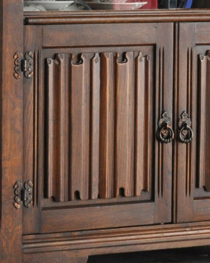 アンティークのキャビネット　アンティーク家具　コンパクトなアンティーク家具、英国のガラスキャビネット（カップボード）。扉には木製の高級感溢れる装飾がデザインされています。(k-1685-f)