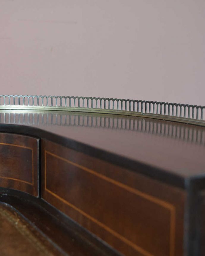 アンティークのデスク・書斎机　アンティーク家具　マホガニー材の女性らしい曲線のデスク（勉強机）、象嵌が美しいアンティーク英国家具。物が落ちにくいようにゴールドの縁があります。(k-1829-f)