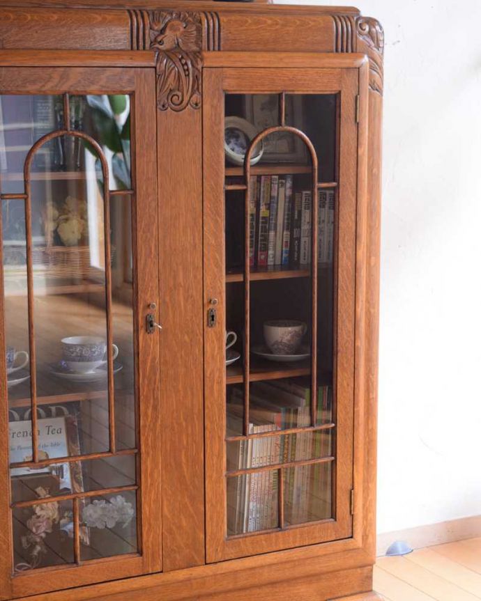 アンティークのキャビネット　アンティーク家具　イギリスから届いたアンティーク家具、凛々しい鳥が守ってくれる美しい木製のブックケース（本棚）。扉に描かれた模様の美しさガラスの扉に描かれた美しい木の模様。(k-2260-f)