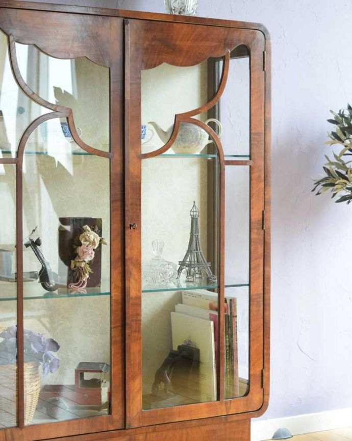 アンティークのキャビネット　アンティーク家具　英国のアンティーク家具、お洒落なかたちの美しいガラスキャビネット（ショーケース）。ガラス越しに見るお気に入りの美しさ…光をたっぷり取り入れてくれるガラス扉と棚板。(k-2294-f)