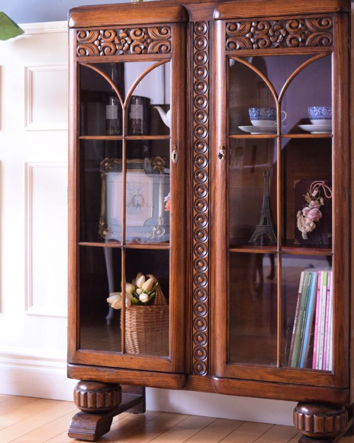 アンティークのキャビネット　アンティーク家具　英国で見つけたアンティーク家具、美しい装飾が入ったブックケース。ガラス越しに中をのぞいてみると･･･アンティークのガラスを通して中に入っているものを見ると、なんだかちょっと高級に見えるんです。(k-2675-f)