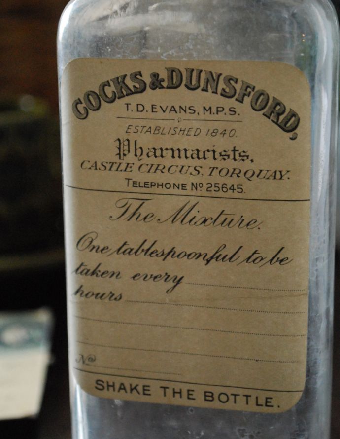 ナチュラルカントリースタイル　アンティーク雑貨　イギリスのステッカー＆目盛り付きアンティークガラスボトル（Cocks&Dunsford）。ステッカー付きのボトルはコレクションしたくなるアンティークアイテムです。(m-1409-z)
