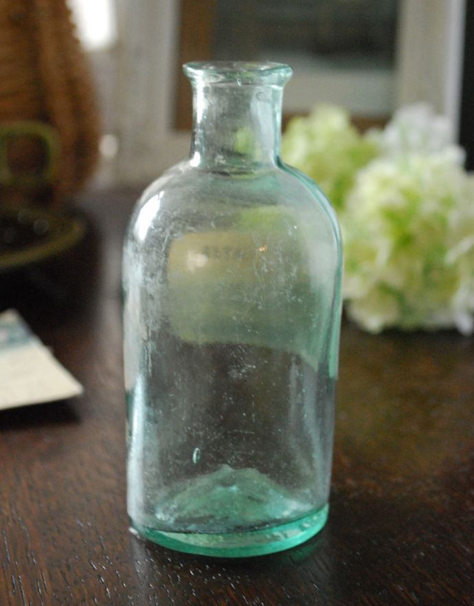 ナチュラルカントリースタイル　アンティーク雑貨　コロンと小さい形が可愛い、ステッカー付きアンティークガラスボトル(DISTILLED WATER)。長年使われてきたボトルはとっても味わい深い一品です。(m-1414-z)