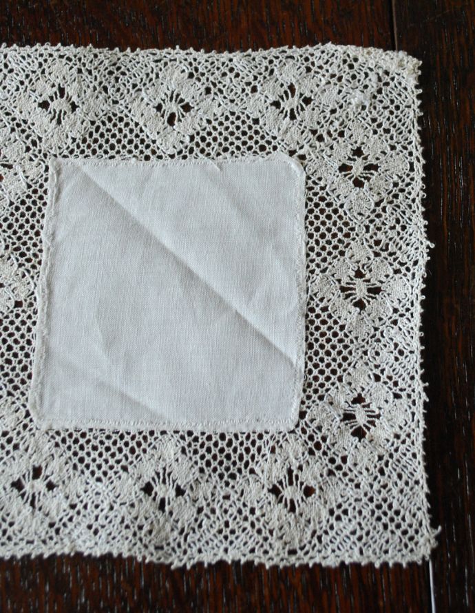 アンティーク 布製の雑貨　アンティーク雑貨　お花の模様に縁取りされた可愛いアンティークハンドメイドレース（ドイリー）スクエアタイプ。一枚一枚手作業で丁寧に編み込まれていますハンドメイドの繊細さとあたたかさがあります。(m-1512-z)