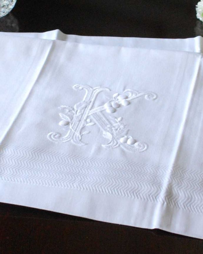ファブリック（布）雑貨　インテリア雑貨　フランスのホームリネンの雰囲気が楽しめるモノグラムが入ったバスタオル「K」。上品なモノグラムのデザインジャガード織りのテキスタイルにイニシャルをオシャレに図案化されたモノグラムが上品に刺繍されています。(n9-035)