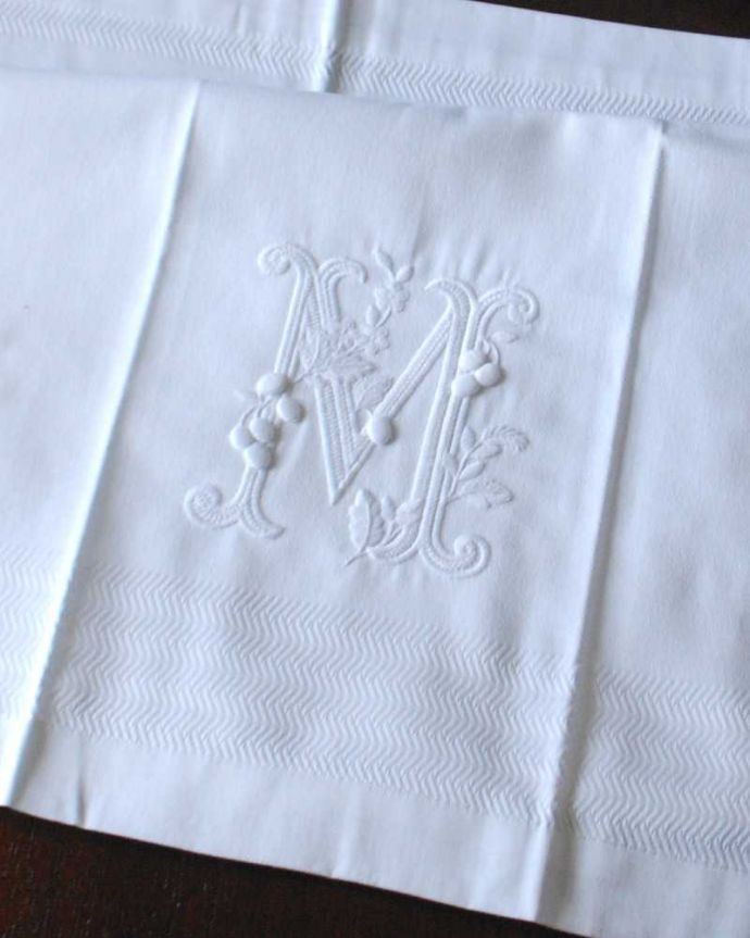 ファブリック（布）雑貨　インテリア雑貨　バスタオル　モノグラム（WH）M　60×108。上品なモノグラムのデザインジャガード織りのテキスタイルにイニシャルをオシャレに図案化されたモノグラムが上品に刺繍されています。(n9-036)