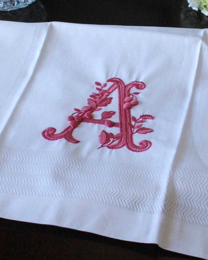 ファブリック（布）雑貨　インテリア雑貨　フランスのホームリネンの雰囲気が楽しめるモノグラムが入ったバスタオル「A」Red。上品なモノグラムのデザインジャガード織りのテキスタイルにイニシャルをオシャレに図案化されたモノグラムが上品に刺繍されています。(n9-045)