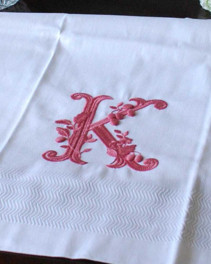 ファブリック（布）雑貨　インテリア雑貨　フランスのホームリネンの雰囲気が楽しめるモノグラムが入ったバスタオル「K」Red。上品なモノグラムのデザインジャガード織りのテキスタイルにイニシャルをオシャレに図案化されたモノグラムが上品に刺繍されています。(n9-047)