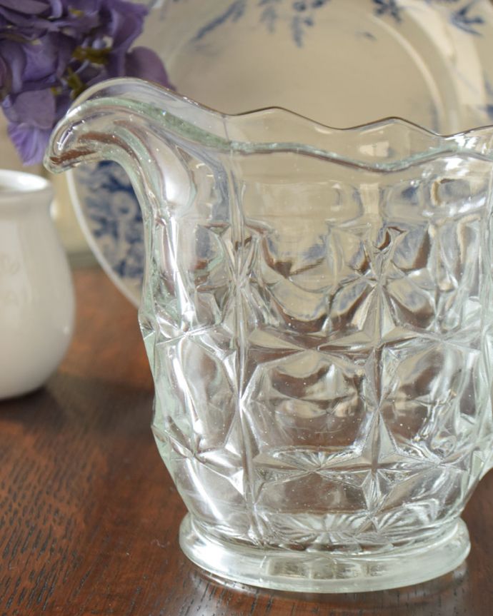 アンティーク 雑貨のガラス小物　アンティーク雑貨　揺らめくデザインに癒されるアンティークのピッチャー（プレスドグラス）。英国の家庭には必ずあるウォータージャグアルコールを飲まない人のためにテーブルの中央にお水を置いて置かれていたウォータージャグ。(pg-3683)