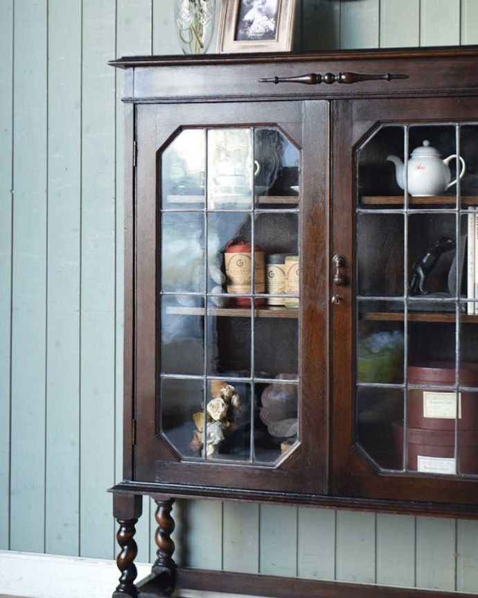 アンティークのキャビネット　アンティーク家具　英国伝統のアンティーク家具、ステンドグラスをはめ込んだブックケース（本棚）。ガラス越しに中をのぞいてみると･･･アンティークのガラスを通して見ると、どんなものでも中に入れたものが、ちょっと高級に見えちゃうんです。(q-1323-f)
