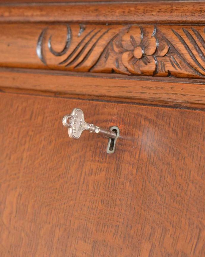 ビューロー　アンティーク家具　リビングで使えるアンティーク英国家具、お花の彫刻が可愛いサイドバイサイド。鍵を使って開けてみましょうアンティークの鍵が一つ付いています。(q-1447-f)