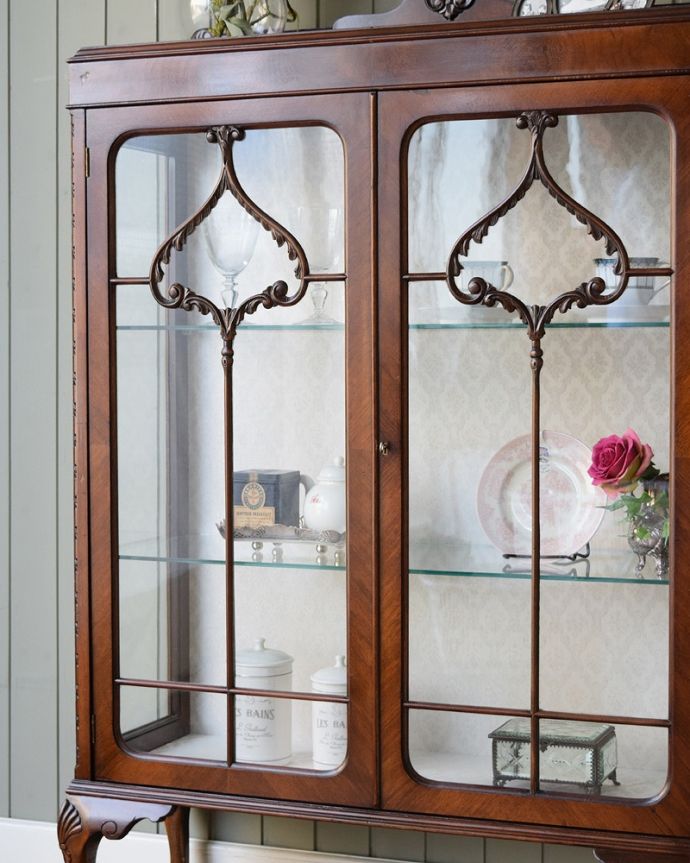アンティークのキャビネット　アンティーク家具　英国輸入のアンティーク家具、繊細な木製の飾りが美しいガラスキャビネット。ガラス越しに見るお気に入りの美しさ…光をたっぷり取り入れてくれるガラス扉と棚板。(q-1829-f)