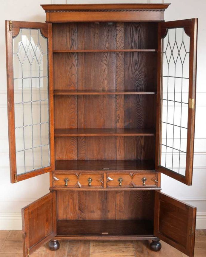 アンティークのキャビネット　アンティーク家具　英国らしい落ち着いたカッコよさ、ステンドグラスが美しいアンティークブックケース。扉の中は、しっかりと収納できる棚板重いものもたっぷり収納できる木製の棚板タイプ。(q-1917-f)