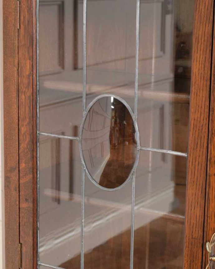 アンティークのキャビネット　アンティーク家具　湾曲ガラスがはめ込まれたステンドグラス扉の英国アンティークブックケース（本棚）。アンティークらしいガラスアンティークでしか手に入れることが出来ないガラスの美しさ。(q-1992-f)