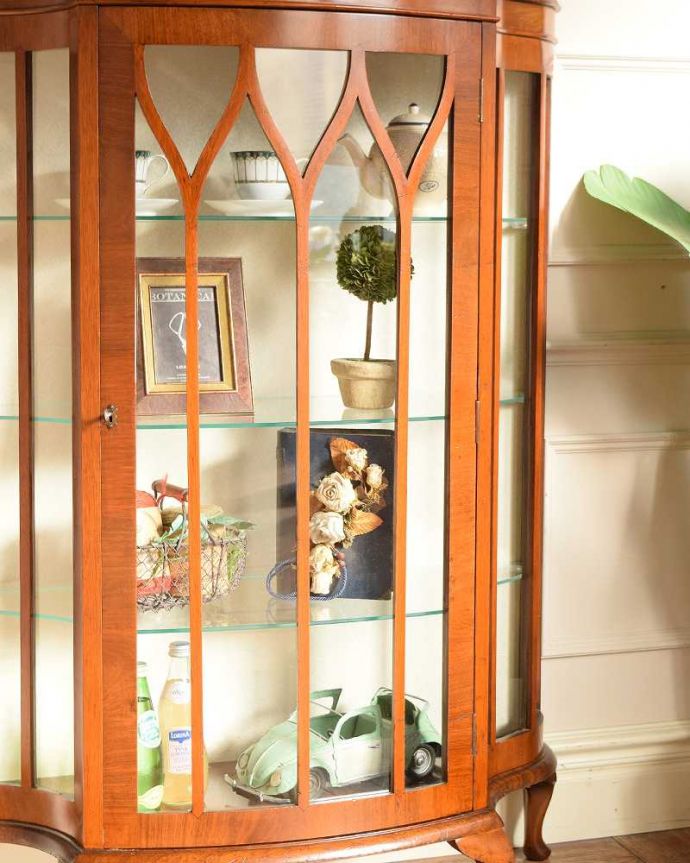 アンティークのキャビネット　アンティーク家具　英国のアンティーク家具、ゴシックデザインの扉が可愛いガラスキャビネット。ガラス越しに見るお気に入りの美しさ…光をたっぷり取り入れてくれるガラス扉と棚板。(q-2014-f)