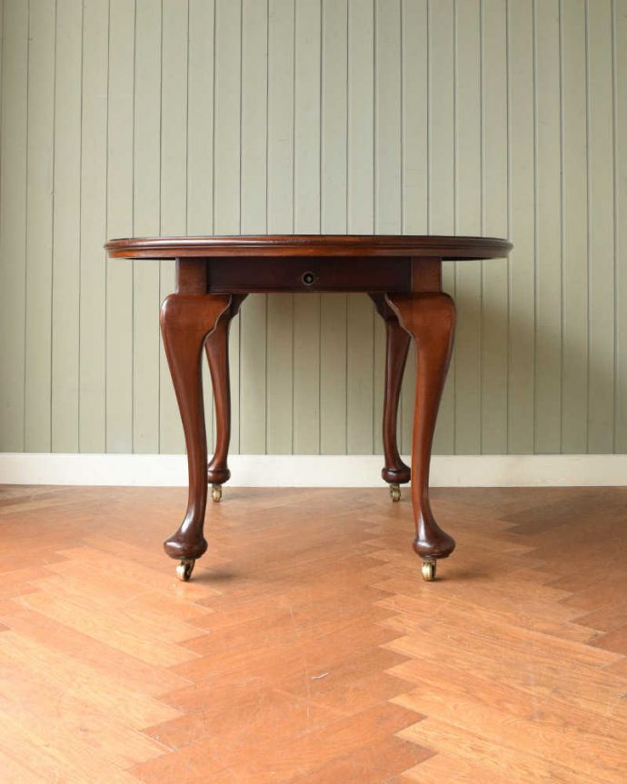 アンティークのテーブル　アンティーク家具　1930年代の英国輸入のアンティーク家具、クイーンアンスタイルのエクステンションテーブル。こちら側から見てみると･･･アンティークは新品ではないので経年変化によるキズはありますが、専門の職人がしっかり修復しました。(q-2051-f)