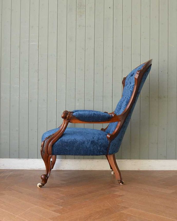 1Pソファ(ラウンジチェア)　アンティーク チェア　ブルーの張地と装飾が美しいウォルナット材のアームチェア、キャスター付きのアンティークナーシングチェア 。横から見ても優雅な立ち姿授乳のために作られた椅子は、座面が低く背もたれの角度もゆったり。(q-284-c)