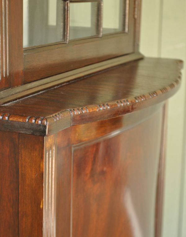 アンティークのキャビネット アンティーク家具 上品なアンティークの英国家具、細長いガラスのショーケース。細かい彫がワンポイントになっています。(j-1342-f)