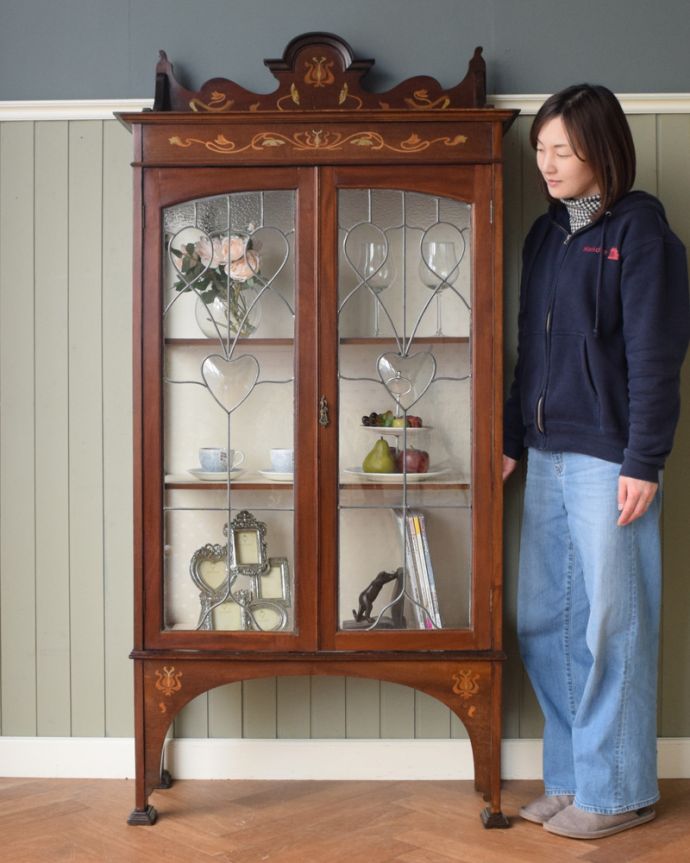 アンティークのキャビネット アンティーク家具 美しい象嵌入りの英国アンティーク、高級感溢れるアールヌーヴォーのガラスキャビネット。ステンドグラスの扉が美しいキャビネット扉がステンドグラスになっているから、キャビネットとステンドグラスの両方を一気に手に入れることが出来ちゃうんです。(j-1644-f)