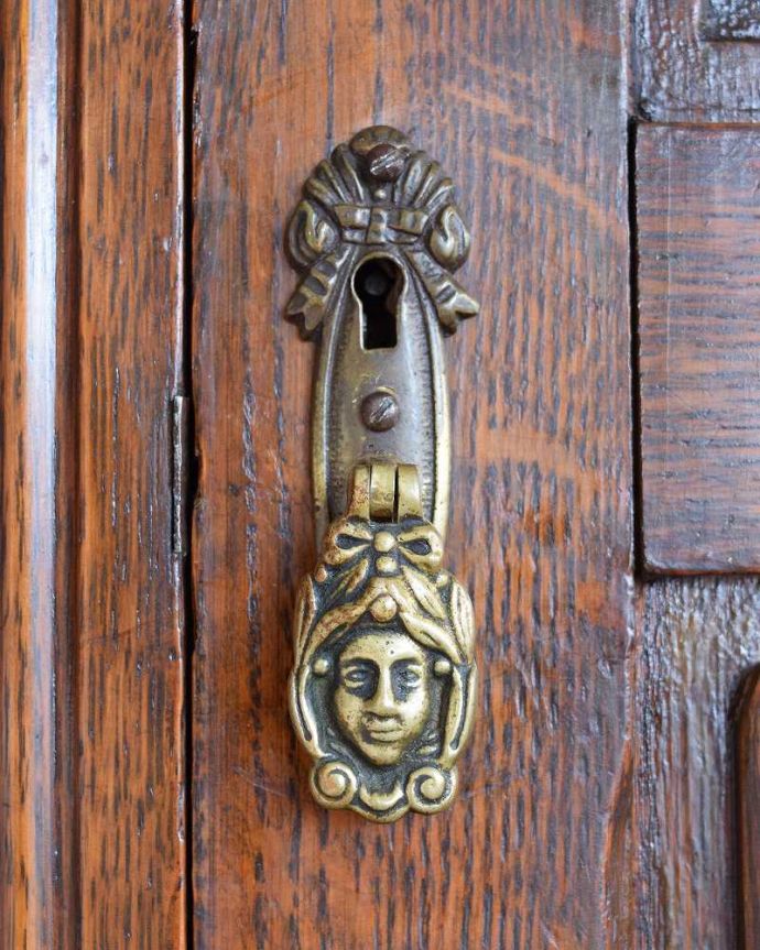 アンティークのキャビネット　アンティーク家具　イギリス輸入のアンティーク家具、豪華な彫りの入ったワードローブ 。アンティークらしい素敵な取っ手取っ手のデザインも美しい･･･こんなところからもアンティークらしさが感じられます。(j-2065-f)