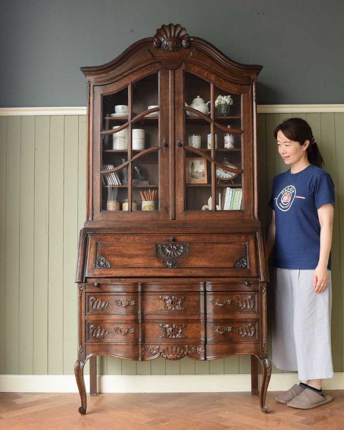 アンティークのキャビネット　アンティーク家具　彫りが隅々まであるアンティーク家具、フランス輸入のアンティークビューローブックケース。優雅さと気品が漂うフレンチビューロー見た目はガラスキャビネットなのに、デスクとチェストの機能も備えたビューローブックケース。(j-2465-f)