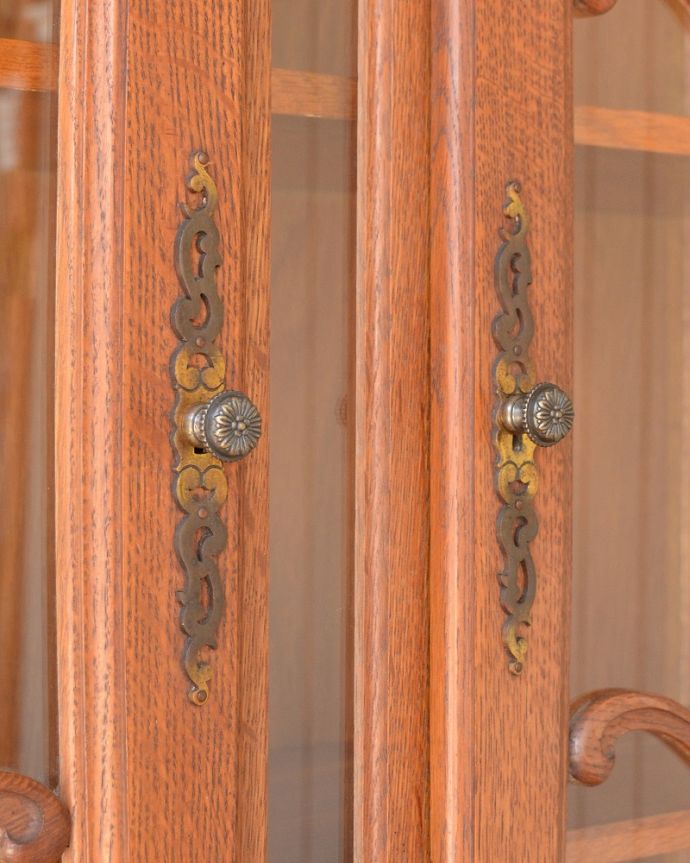 アンティークのキャビネット アンティーク家具 フランス輸入のアンティーク家具、ゴージャスな彫りがエレガントなガラスキャビネット。取っ手にもフランスらしさ芸術的に美しいの取っ手。(j-2505-f)