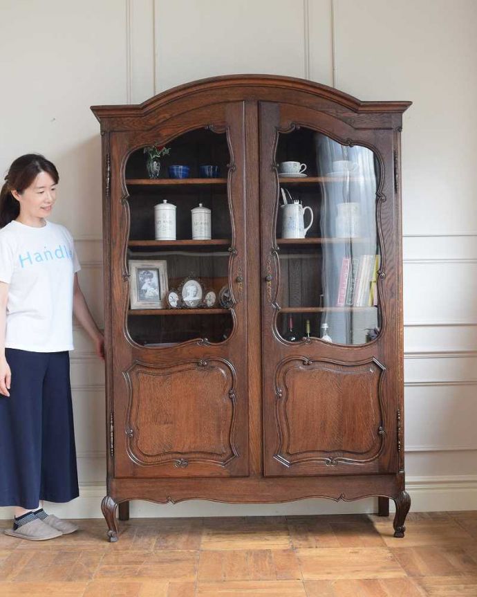 アンティークのキャビネット アンティーク家具 フランスのゴージャスなアンティーク家具、ガラスキャビネット(本棚)。フランスらしい優雅さと風格が自慢ドッシリと重厚感ある佇まいとフランスらしい優雅な彫の両方を贅沢にも兼ね備えたガラスのキャビネット。(j-2508-f)