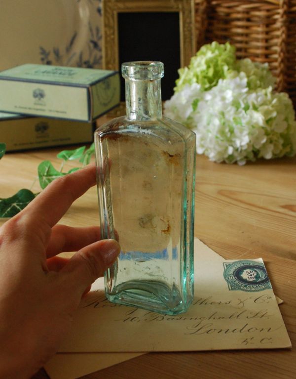 アンティーク ガラスボトル アンティーク雑貨 エンボス入り、爽やかなブルーのアンティークガラスボトル。後ろ側を見ると・・・なんとなくゆがんでいたり、気泡が入っていたり・・・そこがアンティークらしさです。(k-1365-z)