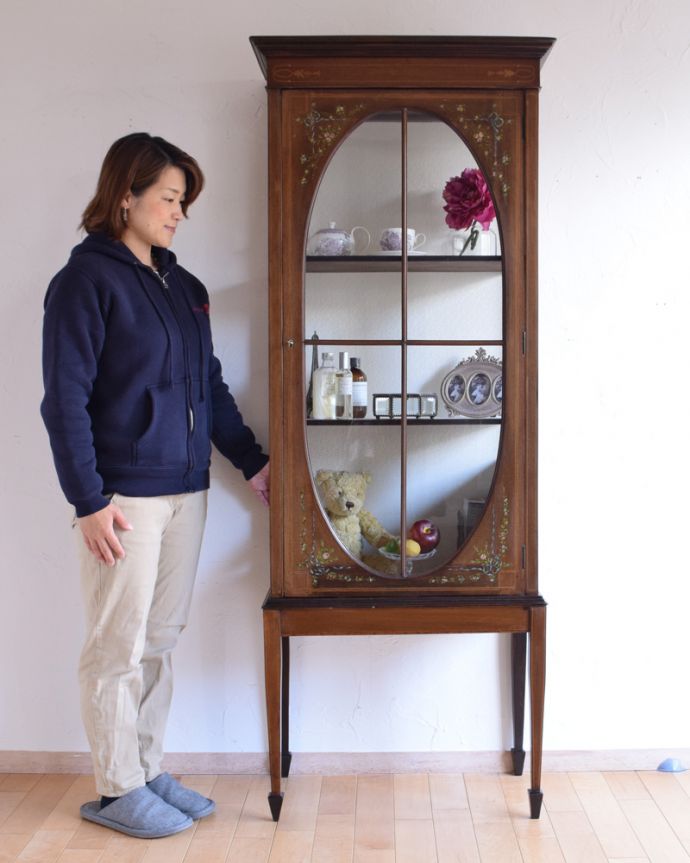 アンティークのキャビネット アンティーク家具 リボンやお花がデザインされたアンティークの英国家具、ガラスキャビネット(飾り棚。ショーケースのように、お気に入りの雑貨や食器を並べてみましょう。(k-1560-f)