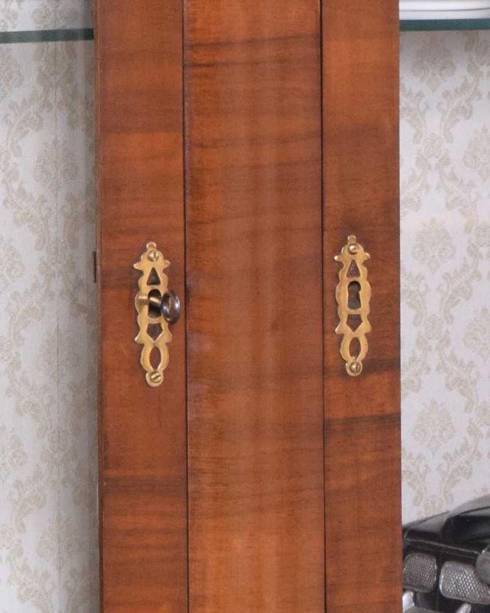 アンティークのキャビネット　アンティーク家具　アンティーク英国輸入家具、カーブが美しいシルエットのガラスキャビネット。アンティークらしいカギの取っ手鍵が取っ手になっています。(k-1781-f)