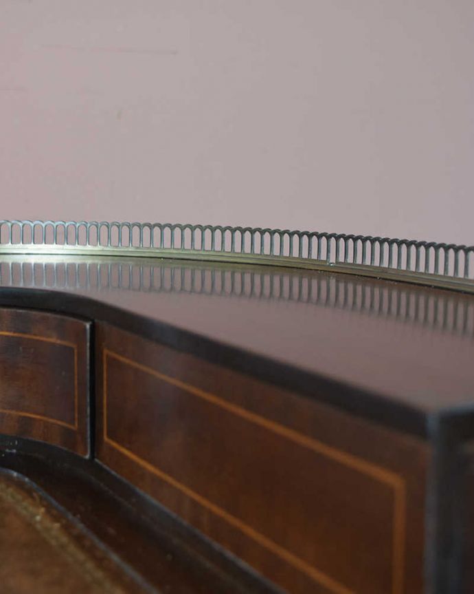 アンティークのデスク・書斎机　アンティーク家具　マホガニー材の女性らしい曲線のデスク（勉強机）、象嵌が美しいアンティーク英国家具。物が落ちにくいようにゴールドの縁があります。(k-1829-f)