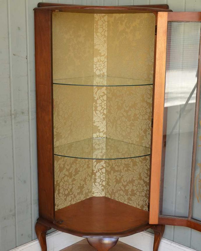 アンティークのキャビネット アンティーク家具 装飾が上品なアンティーク家具、英国から届いたウォルナット材のコーナーキャビネット。扉を開けて中を見てみると…職人がキレイに修復して、背板も新しい生地に張替えました。(k-1852-f)