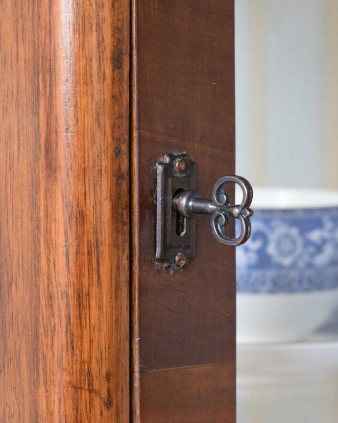 アンティークのキャビネット　アンティーク家具　シンプルな美しさが大人っぽい、ウォルナット材のアンティークガラスキャビネット。開ける度にワクワクアンティークらしくカギが取っ手の代わり。(k-1856-f)