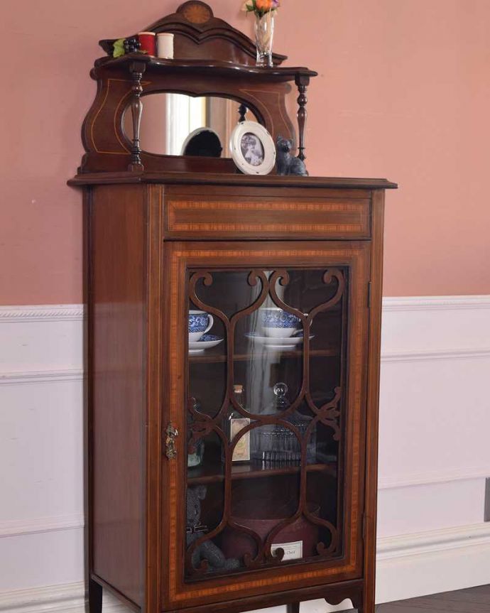 アンティークのキャビネット　アンティーク家具　ミラーがついた装飾が美しいアンティーク家具　ガラスキャビネット。扉に描かれた模様の美しさガラスの扉に描かれた美しい木の模様。(k-1879-f)