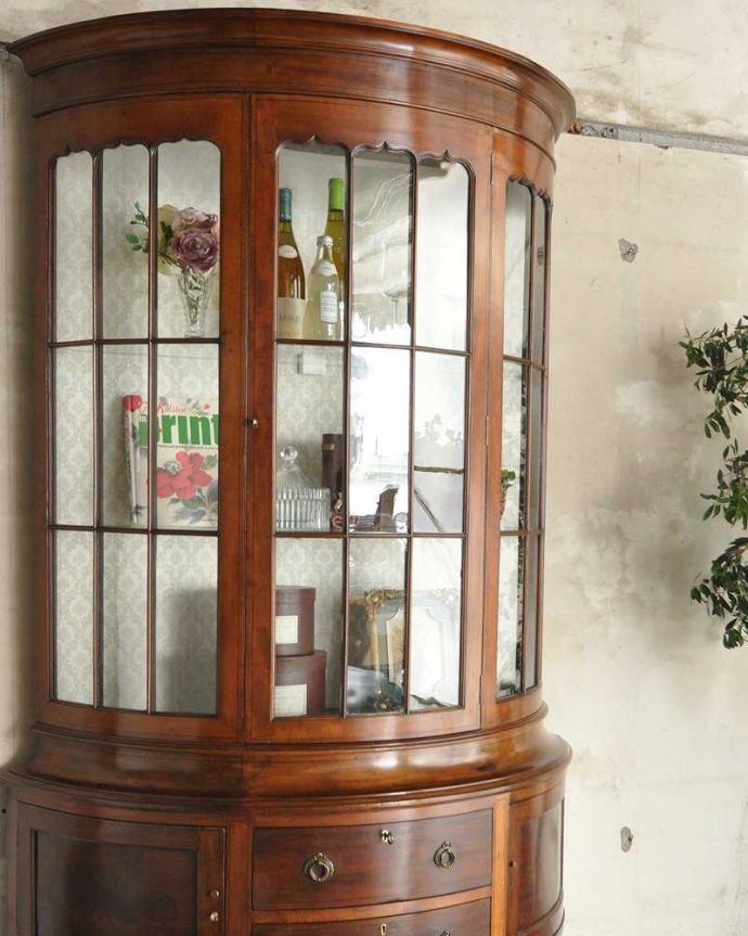 アンティークのキャビネット　アンティーク家具　英国輸入のアンティーク家具、マホガニー材を使ったキャビネット（飾り棚）。180度クルッと見渡せるハーフムーンにうっとり･･･180度、どの角度からも中が見えてみんなを魅了するガラスキャビネットの美しさ。(k-1916k-f)