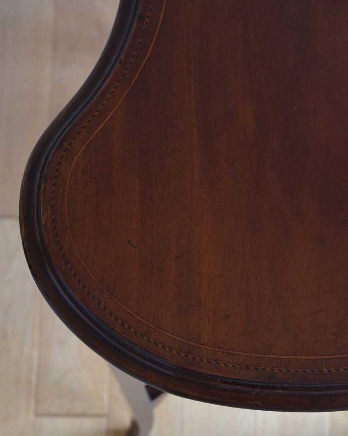 アンティークのテーブル　アンティーク家具　美しいアンティークの英国輸入家具、キドニー型のオケージョナルテーブル（棚付き）。天板を近づいてみると…アンティークだから手に入れることが出来る天板に使われている銘木の美しさにうっとりです。(k-1927-f)