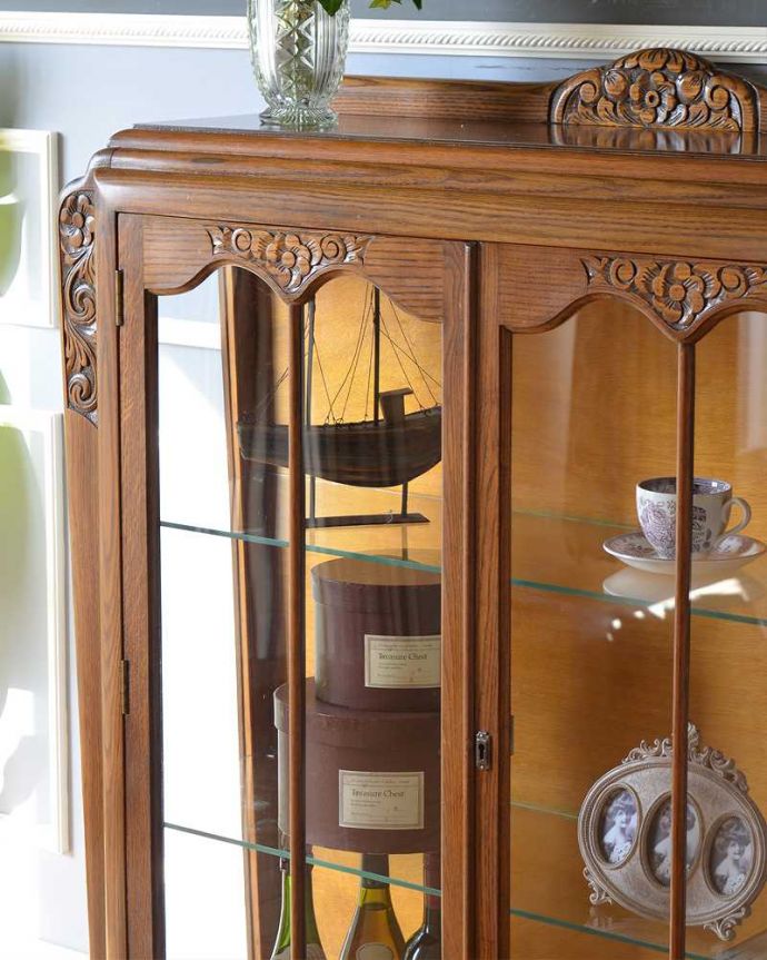 アンティークのキャビネット　アンティーク家具　お花の彫刻が華やかなアンティークキャビネット(ショーケース)。ガラス越しに中をのぞいてみると･･･アンティークのガラスを通して中に入っているものを見ると、なんだかちょっと高級に見えるんです。(k-1963-f)