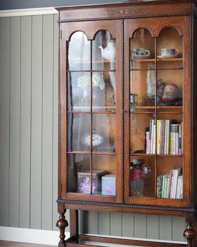 アンティークのキャビネット アンティーク家具 木のアーチが美しいガラス扉のアンティーク家具、イギリス輸入のブックケース。ガラス越しに中をのぞいてみると・・・アンティークのガラスを通して中に入っているものを見ると、なんだかちょっと高級に見えるんです。(k-1986-f)