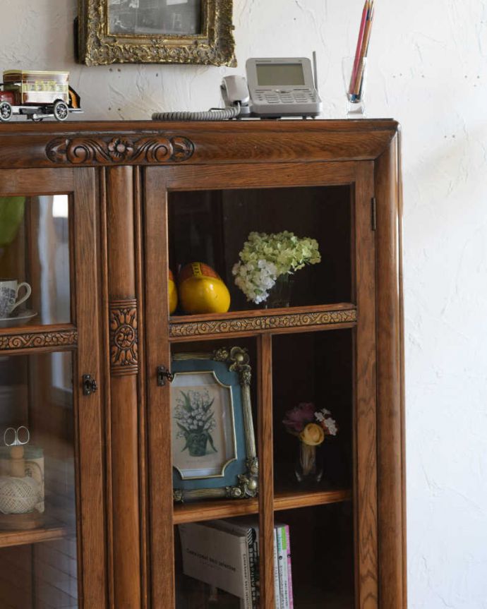 アンティークのキャビネット　アンティーク家具　華やかなアンティークの英国輸入家具、オーク材のブックケース（本棚）。ガラス越しに中をのぞいてみると･･･アンティークのガラスを通して中に入っているものを見ると、なんだかちょっと高級に見えるんです。(k-2046-f)