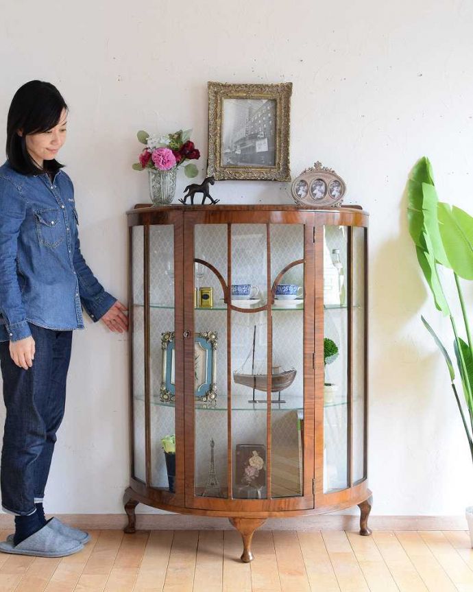 アンティークのキャビネット アンティーク家具 美しいアンティーク家具、イギリス輸入のウォールナット材のガラスキャビネット。どこからでも中が見える半月型のキャビネット半月型をしたハーフムーンのキャビネットは、グルっと180度、どの場所からも中が美しく見える人気のキャビネットです。(k-2068-f)